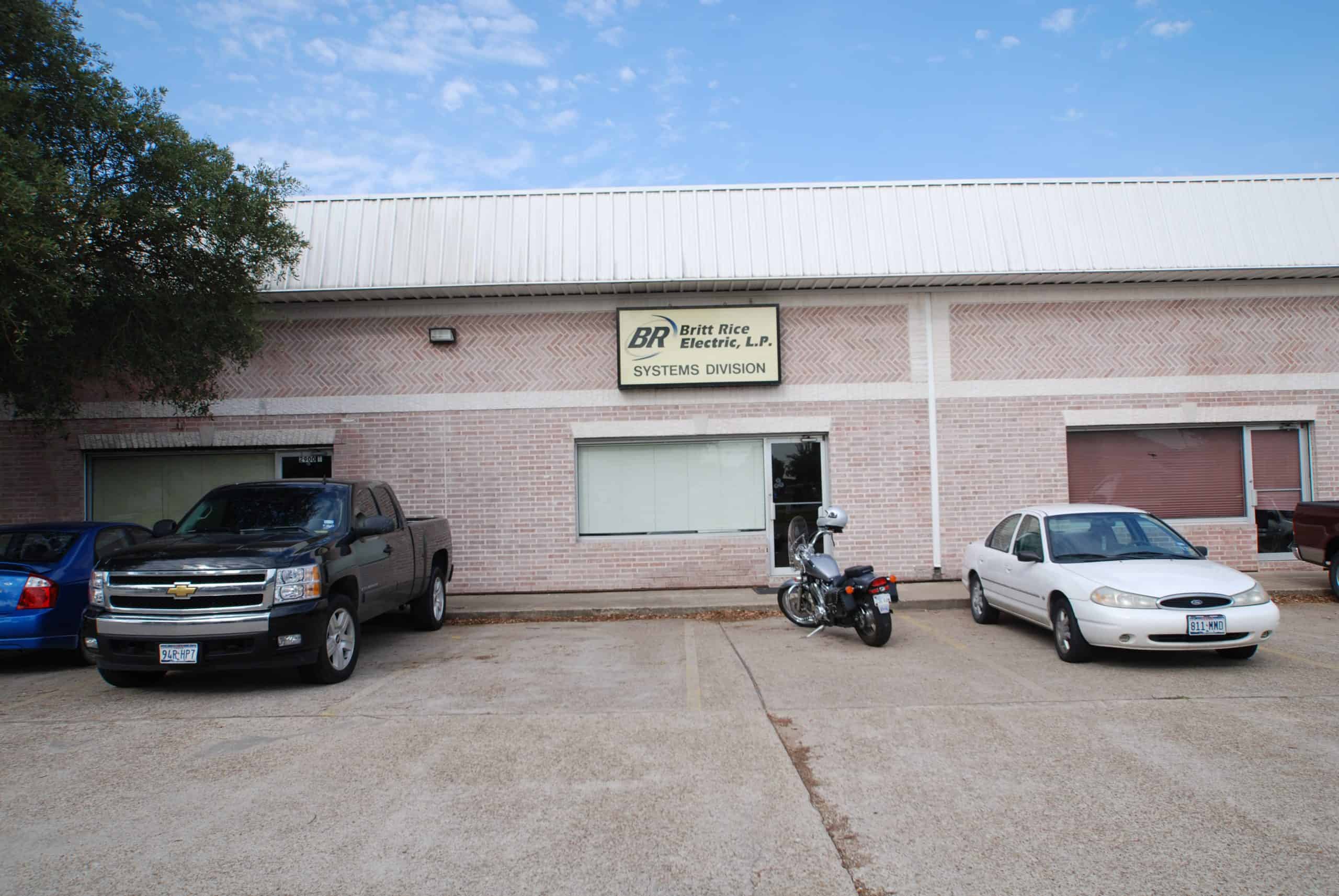 Professional electrical contractor office with parking, featuring vehicles and signage.