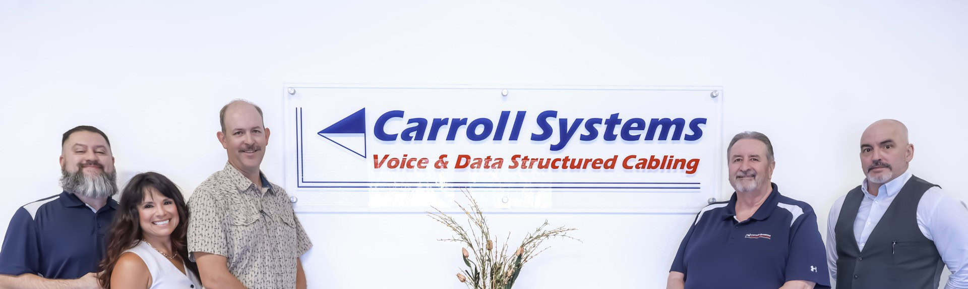 Image of Britt Rice Electric staff in front of Carroll Systems sign, specializing in electrical services and structured cabling.