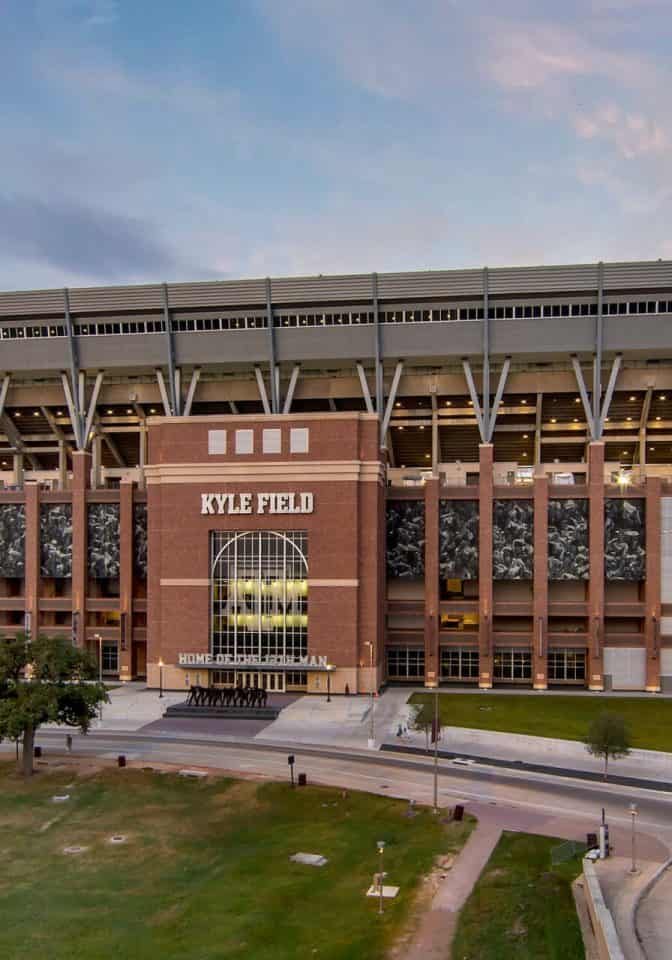 Stadium exterior illuminated during dusk, showcasing electrical systems and lighting setup.