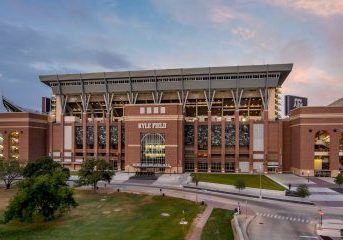 Stadium exterior illuminated during dusk, showcasing electrical systems and lighting setup.